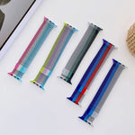 Four-color Milanese replacement strap for Apple Watch displayed in a stylish arrangement on a tabletop.